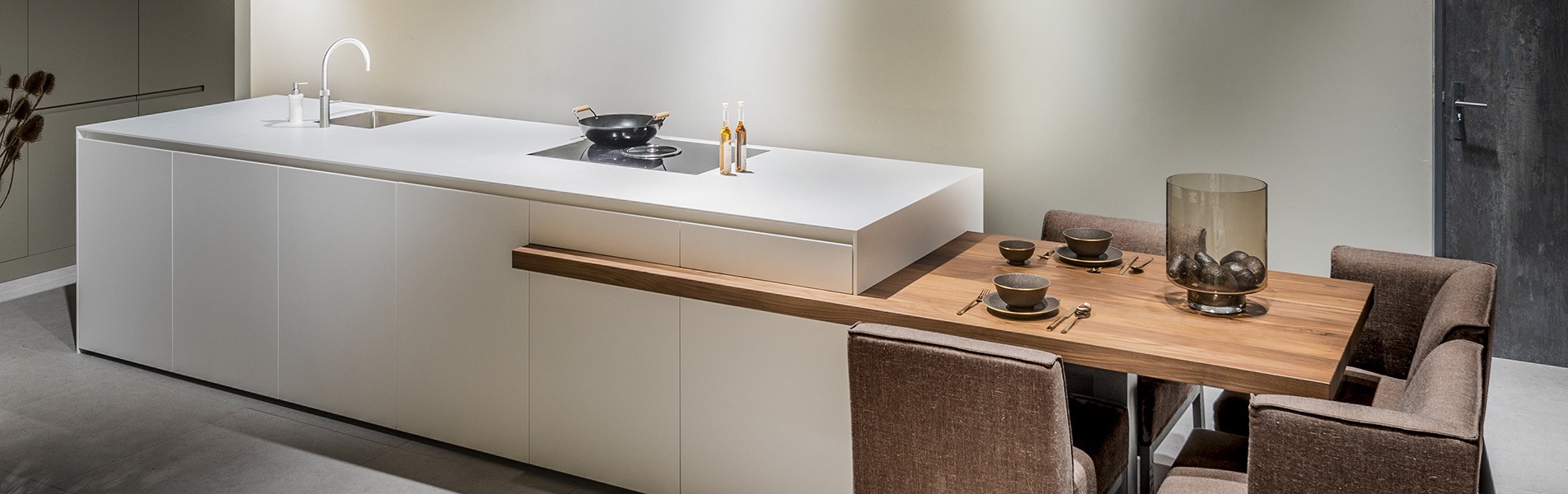 Corian-kookeiland-tafel-keuken-op-maat-keukens-zwart-wit-grijs-ontwerpen-inspiratie-1903-1 Corian kookeiland, wit keukeneiland met geïntegreerde massief houten eettafel of bar. Tijdloze keuken op maat, B DUTCH design keuken. Kom keuken inspiratie opdoen in onze fabrieksshowroom in Cuijk.