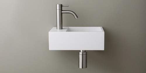 Solid Surface Corian toiletfontein, wasbak of wastafeltje voor op het toilet. Dit mat witte Corian toiltfonteintje kan met kraangat of zonder kraangat geleverd worden. De wasbak uitsparing zit rechts. Het Basics toiletfontein Rechts 300 heeft een lengte van 30 cm, diepte van 18 cm en hoogte van 10 cm.