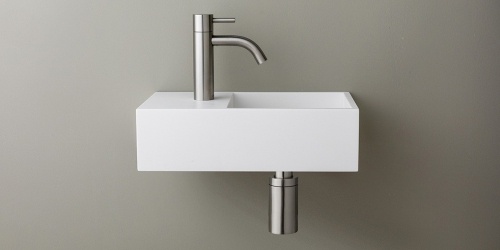 Solid Surface Corian toiletfontein, wasbak of wastafeltje voor op het toilet. Dit mat witte Corian toiltfonteintje kan met kraangat of zonder kraangat geleverd worden. De wasbak uitsparing zit rechts. Het Basics toiletfontein Rechts 350 heeft een lengte van 35 cm, diepte van 18 cm en hoogte van 10 cm.