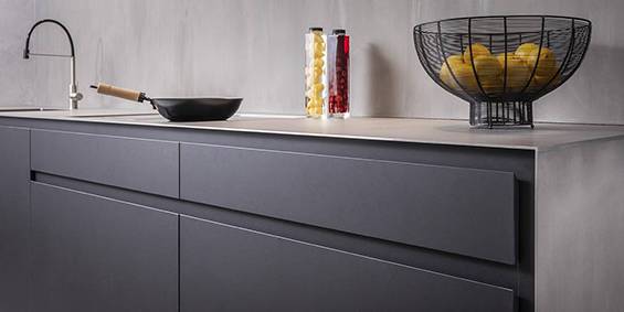 Zwarte-keuken-stalen-blad-aanrechtblad-staal-design-keukens Design keuken RVS blad, zwart Fenix hout fineer kasten. Moderne strakke keuken. Maatwerk keuken binnen B DUTCH luxe keuken concepten.